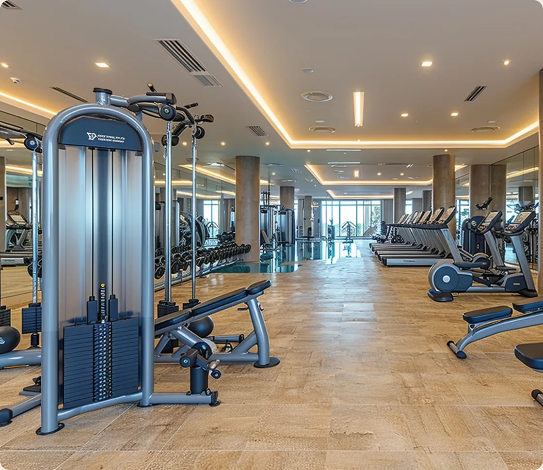 The residents' gymnasium, the lap pool visible beyond the treadmills